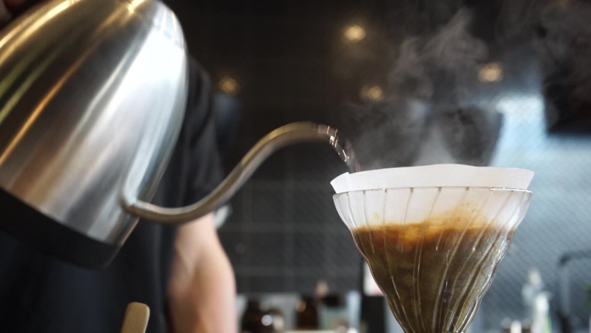 Perfect loop cinemagraph of barista brewing V60 filter coffee, hand pour over using a stainless steel goose neck kettle. Royalty-Free Stock Footage #1073425232