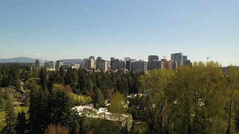 Cinematic 4K rise and reveal aerial drone shot of the city center of Bellevue near Downtown Park and Bellevue Square, skyscrapers, office and apartment buildings near Seattle, Washington