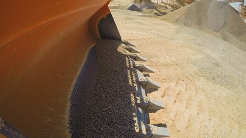Interesting Point of View of loading and dumping gravels into a truck, Industrial machinery at sand quarry. 4k footage