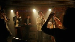 DOLLY OUT CU to WIDE People dancing during concert of a modern jazz band playing on a stage of a small crowded venue. Shot with 2x anamorphic lens - Powered by Shutterstock - Get 15% off with code: PIKWIZARD15