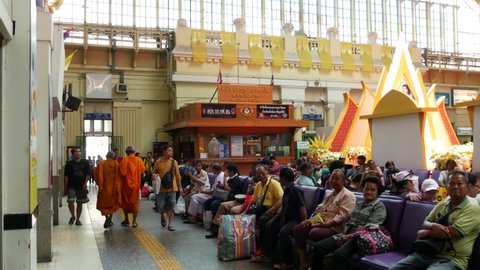 BANGKOK, THAILAND - 11 JULY 2019: Hua Lamphong railroad station, state railway transport infrastructure SRT. Buddhist holy Monk in traditional orange robe. Monks yellow religious clothes among people