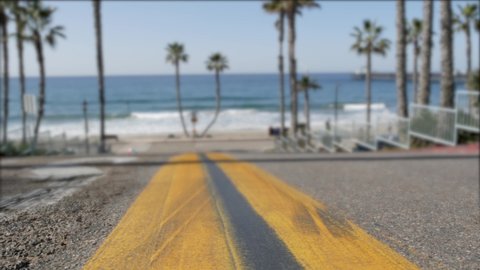 Road with yellow line, pacific ocean beach, Oceanside California USA. Tropical summertime palms, waterfront street. Defocused summer coast near Los Angeles, sunny day, beachfront atmosphere. Sea waves