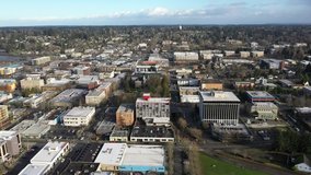 Cinematic aerial drone bird's-eye panning footage of commercial and residential areas, stores and businesses downtown, in the historic district of Olympia, Pierce County, Washington