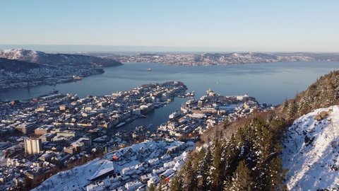 Aerial shot over Bergen Cityscape from hillside mountain with snow - Norway