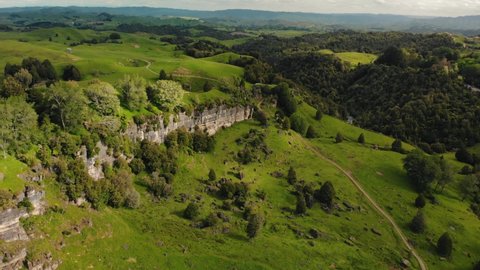 aerial footage new zeland wild nature park green meadow hills and wall rock formation unpolluted area
