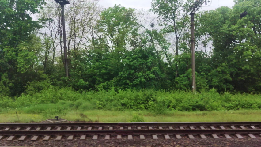 View from window of speed train on landscape of beautiful nature field road with forest Royalty-Free Stock Footage #1073455532