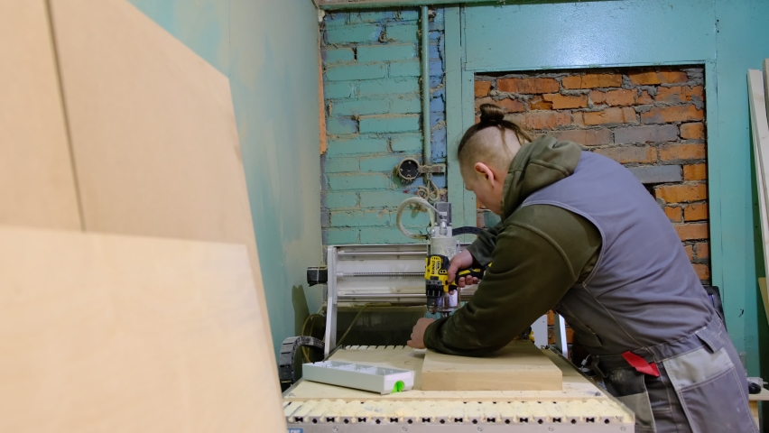 Close up. Carpenter holding a measure tape on the work bench. Woodwork and furniture making concept. Carpenter in the workshop marks out and assembles parts of the furniture cabinet