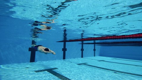 Male athlete swimming underwater in a close up