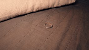 Detective in latex glove examines a ring on a sofa. This video can be used for an investigative scene