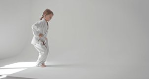 The girl performs lunges and keeps her hands on her belt. Video where a child performs sports exercises.