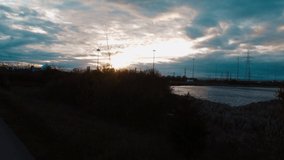 A 4K aerial footage of a tranquil lake near the highway road under a cloudy sunset sky