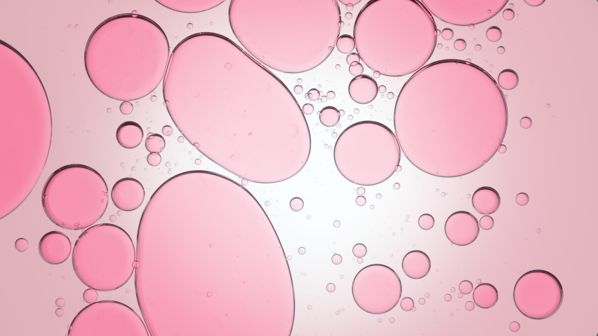 Pink different sized transparent bubbles move slowly and spontaneously in clear fluid against pale pink background   Background for skincare cosmetics advertisement shot Royalty-Free Stock Footage #1073480507