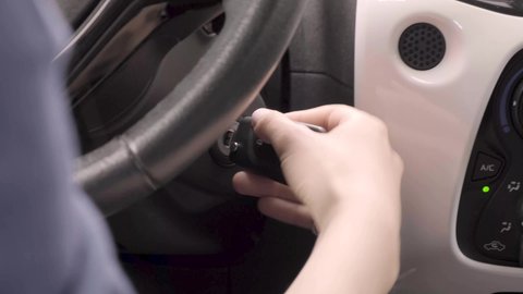 sliding car keys into car switch starting the engine. Starting car engine. a woman's hand Igniting car. The driver inserts the ignition key into the ignition lock, turns it and starts engine