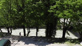 Aerial video from the drone. Landscape with a view of the mountain river Bzyb in Abkhazia, slender girls on the shore, and extreme sportsmen of water tourists preparing catamarans for rafting.