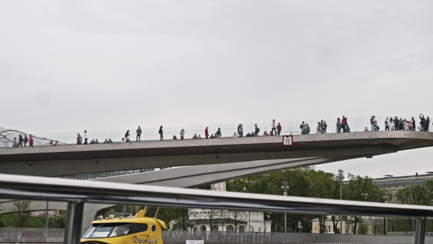 Unrecognizable people tourists stand on soaring bridge taking photos and enjoying view. Touristic life in Moscow