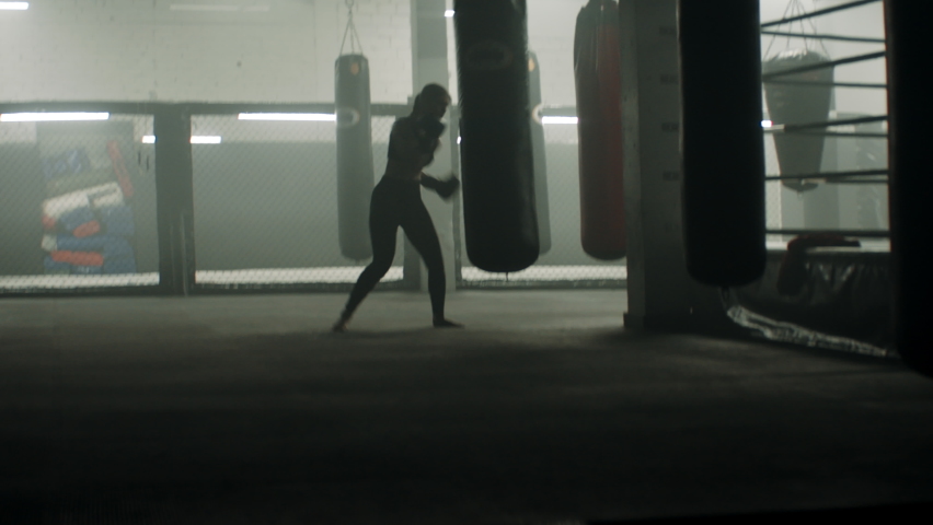 HANDHELD WIDE to CU Caucasian female boxer practicing punches in the boxing gym. Shot with 2x anamorphic lens Royalty-Free Stock Footage #1073501915