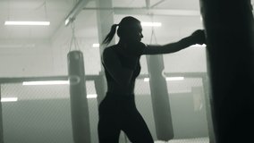 HANDHELD WIDE to CU Caucasian female boxer practicing punches in the boxing gym. Shot with 2x anamorphic lens - Powered by Shutterstock - Get 15% off with code: PIKWIZARD15