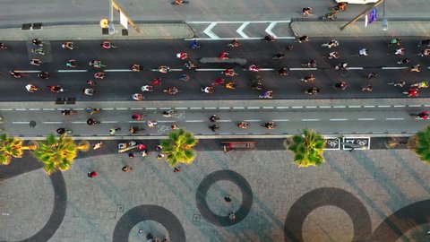 Aerial Forward Shot Of People Cycling On Road During Rally In City, Drone Flying Over Tress On Sidewalk - Tel Aviv, Israel
