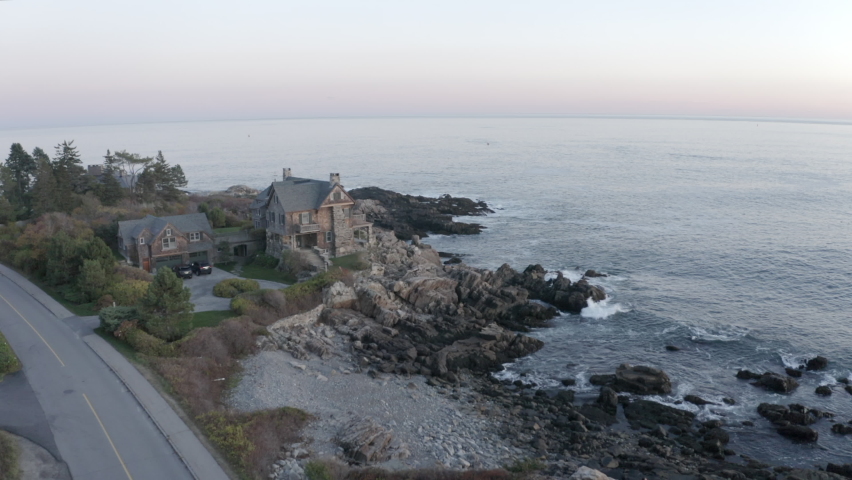 Aerial Moving Forward Over A Large Private Home Perched On A Rocky New England Coast With Crashing Surf, Clear Skies, And Warm Morning Sunlight - Kennebunkport, Maine