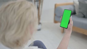 Old Woman Looking at Smartphone with Green Screen on Yoga Mat