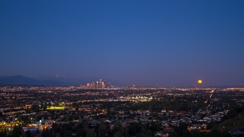 Lockdown Time Lapse Shot Of Illuminated City Against Clear Sky, Moon Moving Upwards In City - Los Angeles, California