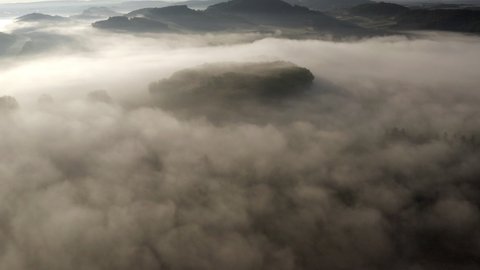 Aerial Panning Fog Covered Hills With A Tilt-Up To Reveal Hilltop Castle Ruins On The Distant Horizon, With Warm Dawn Sunlight And Dark Shadows - Drei Gleichen, Germany