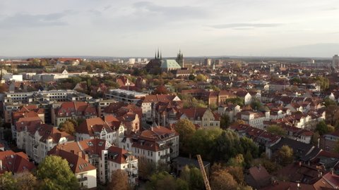 Aerial Moving Forward Over Old Historic German Town And Towards A Soaring Cathedral In The City Center, With Timber Framed Homes, Narrow Streets, And Steep Red-Tiled Roofs - Erfurt, Germany
