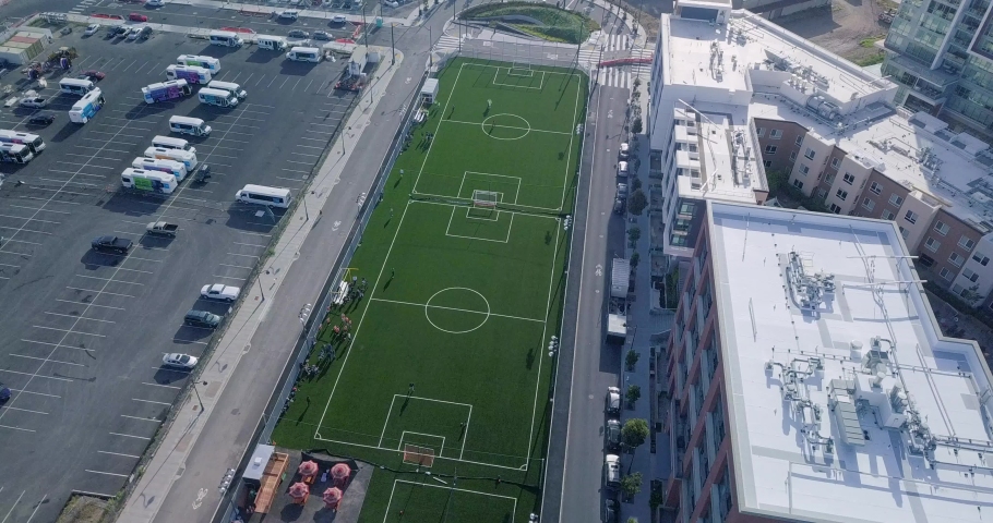 Static shot of soccer field pan down of middle of city