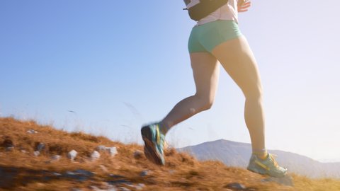 A female marathon runner's legs running downhill in slow motion
