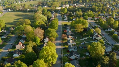 Residential suburban housing district area in USA. American homes in quiet neighborhood. Aerial truck shot at golden hour.