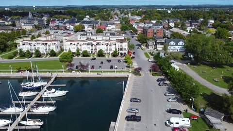 Waterfront residential housing developments with views of yachts and sail boats docked in tourism town; aerial 4k