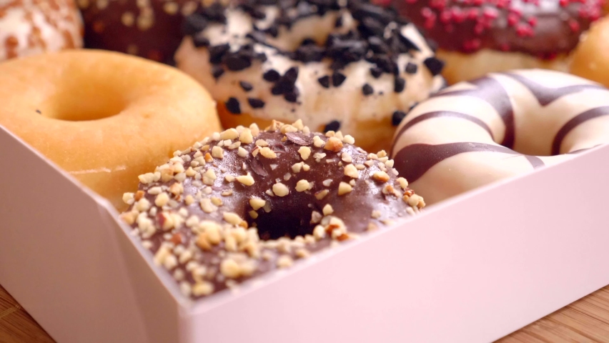 Assortment of donuts of different flavors in a box.  | Shutterstock HD Video #1073555816