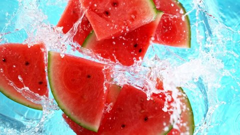 Super Slow Motion Shot of Falling Fresh Watermelon Slices into Water.