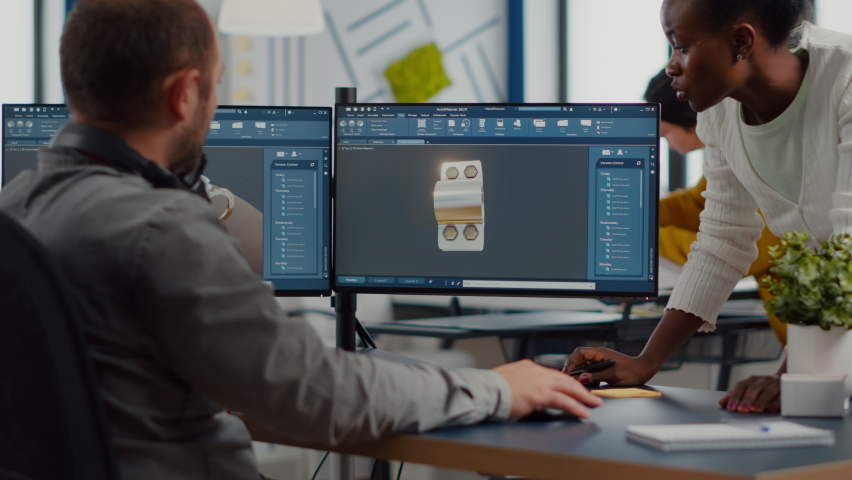 Diverse team discussing about industrial project using dual monitors setup to desing 3D gears and metalic clamp in CAD software. Industrial engineer and african manager working in creative office