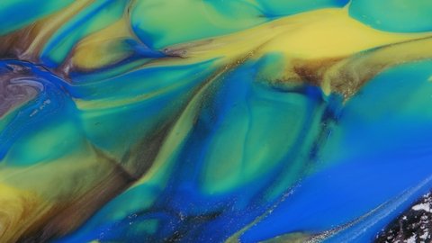 Blue, yellow, green, streaks on a colorful background. Abstract light pastel streams flow along the plane on a blue background. Marble texture. Fluid art. Liquid abstractions.
