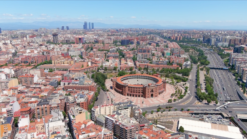 Madrid: Aerial view of capital city of Spain, famous bullring (bullfighting arena) Plaza de Toros de Las Ventas, modern office buildings (skyscrapers) skyline on horizon—panorama of Europe from above