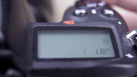 Male photographer adjusts settings on DSLR camera close up