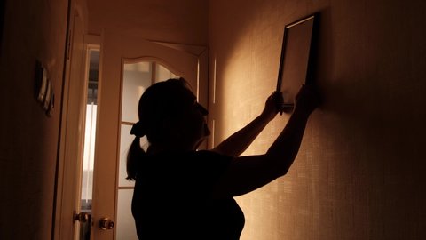 Silhouette of a woman broadcasting a picture frame on the wall of new housing