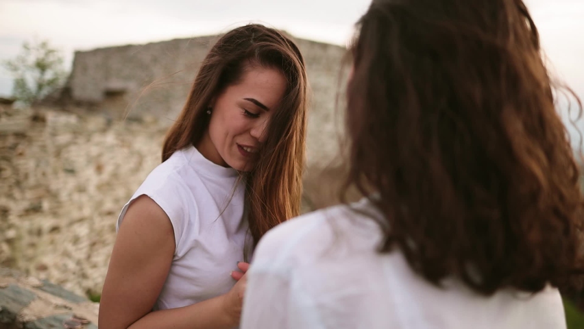 Happy young hispanic and caucasian attractive girls and friends having fun. Lesbian couple spending time together in sunny day. LGBTQ concept. Travelling couple doing sightseeing. Diverse love pride.