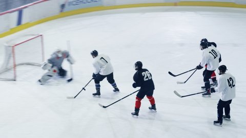 Ice Hockey Rink Arena Game Start: Two Players Brutal Face off, Referee Drops the Puck, Leading with Masterful Dribble Player Scores Goal when Goalie Misses the Puck. Aerial Drone High Angle Shot