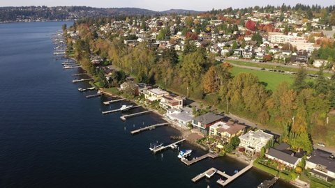 Cinematic aerial drone shot of Market, Norkirk, Kirkland, Moss Bay, Lake Washington in autumn foliage, commercial, residential neighborhood near Bellevue and Seattle, King County, Washington