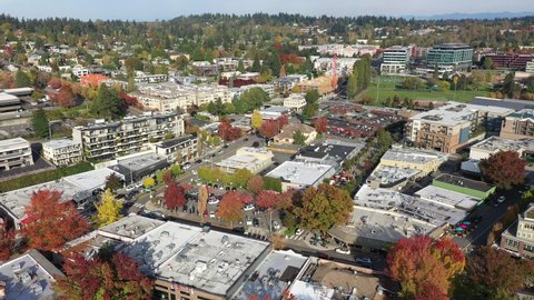 Cinematic aerial drone footage of downtown Kirkland, Marina Park Pavilion, Moss Bay, Peter Kirk Park in autumn foliage, commercial, residential neighborhood near Bellevue in King County, Washington