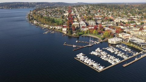 Cinematic drone dolly footage of Kirkland, Marina Park Pavilion, Moss Bay, Lake Washington in autumn foliage, commercial, residential neighborhood near Bellevue and Seattle, King County, Washington