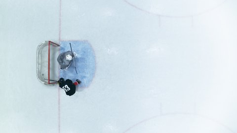 Top View Ice Hockey Rink Arena: Professional Forward Player Masterfully Dribbles, Breaks Defense, Hitting Puck with Stick Scores Goal, Goalie Missed it. Flying Aerial Drone Wide Shot