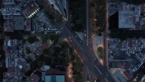 Aerial birds eye overhead top down panning view of traffic in streets of downtown. Flying drone in evening, low light. Mexico city, Mexico.