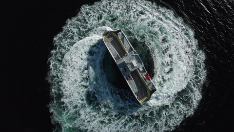 Modern battery powered zero-emission car ferry with extreme monouverability doing 360 spin. Mf Hjellestad Norway aerial drone shot