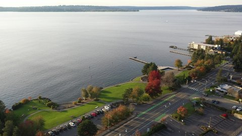 Cinematic drone tracking footage of Yarrow Bay Marina, Houghton Beach Park, Lakeview, Central Houghton, Kirkland, Lake Washington, affluent residential neighborhood near Bellevue in autumn foliage