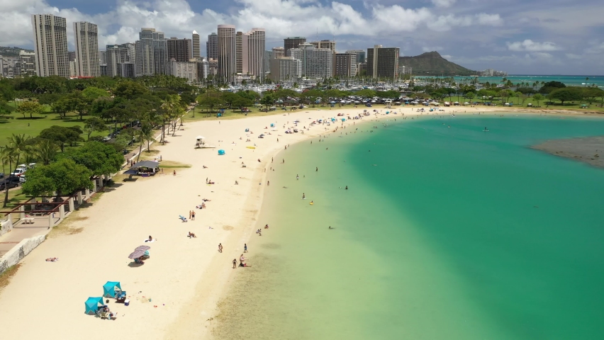 Cinematic 4K aerial drone footage of high-rise hotels with sandy beaches on the shore of Ala Moana, vibrant, popular tourist destination near Honolulu on Oahu island in Hawaii known for its surfing