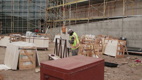 San Diego, California, USA - June 7, 2019: Stonemasons are receiving and organizing a shipment of stone that will be installed on the exterior walls of a new building that is under construction.