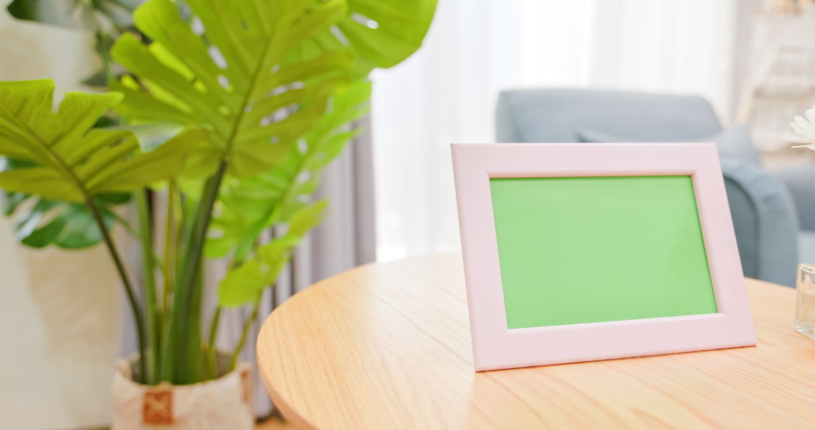 close up of photo frame with green copy space on table in living room at home Royalty-Free Stock Footage #1073609402